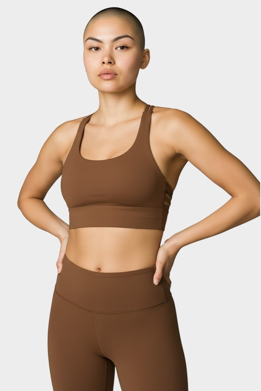 COHYX LLC purple wireless sports bra with criss-cross straps, made of soft, breathable fabric for yoga and running.